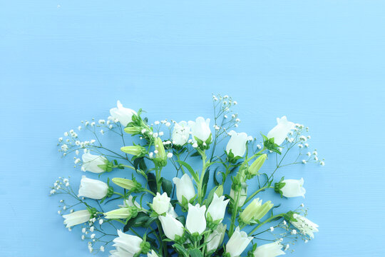 spring bouquet of white bell flowers over blue background