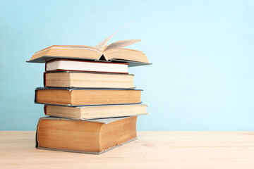 Stack of old books over blue background