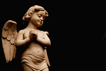 Fototapeta na wymiar Death concept. Little sad angel . Fragment of an ancient statue.