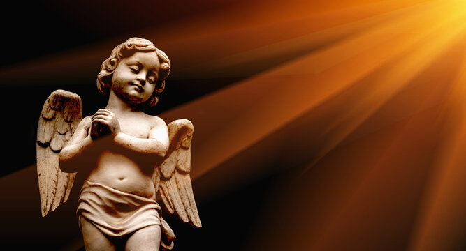 Little beautiful guardian angel statue in sunlight as a symbol of strength, truth and faith. Horizontal image.