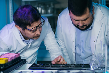 Team of Young Biologists People Analyzing Plants Seeds, Food Scientists Men Work in Agriculture Research Laboratory.