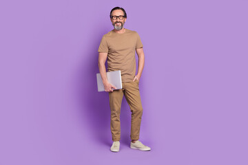 Full length photo of mature man standing hold laptop representative isolated over violet color background