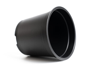small black plastic pot for indoor flowers on a white background. accessories for seedlings of plants at home.