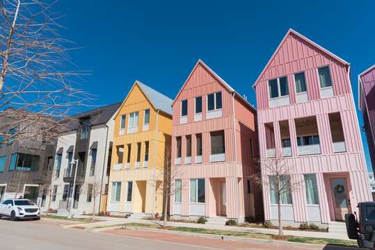 Front yard view row of multicolor brand new three-story city houses with metal roofs against sunny clear blue sky in Wheeler District, Oklahoma City, USA