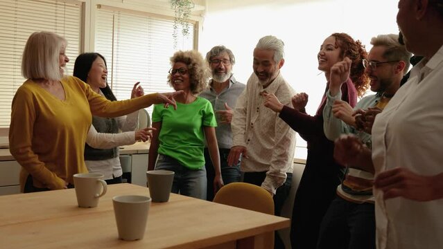 Multiracial people dancing having fun inside home kitchen - Multi-generational friends concept