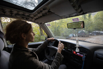 Woman driving old car trough non secure neighbourhood