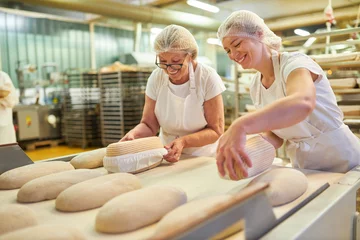 Abwaschbare Fototapete Brot Bäckerlehrling mit Chef beim Brotbacken unter Anleitung