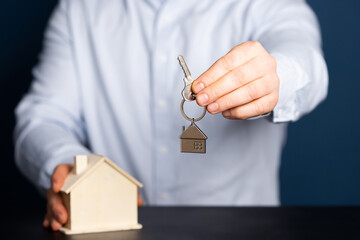 Hands with little house and key. Real estate and construction concept.