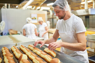 Man as a baker in training baking donuts