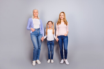Naklejka premium Full size photo of three cheerful friendly people standing hold arms isolated on grey color background