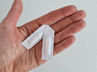 Person hand with medical suppository of vaginal rectal tablets
