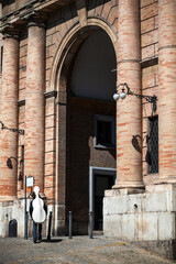 Entering medieval main gate entrance in the city of Macerata Italy by a musician