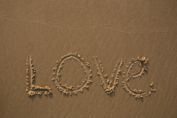The text Love written in the sand
