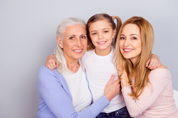Portrait of three positive peaceful people hugging care support toothy smile isolated on grey color...