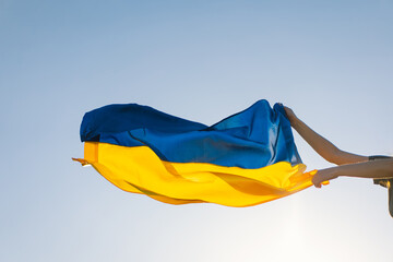 Woman holding a yellow and blue flag of Ukraine in outdoors. Independence Day. Flag Day. Constitution day. Woman in traditional embroidery with flag of Ukraine