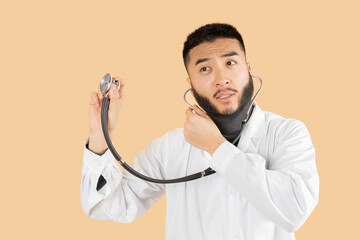 Asian man in Doctor uniform auscultation beige background