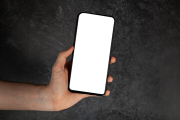 Smartphone in hand. White screen, dark background.