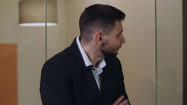 Close-up portrait of handsome brunette bearded Caucasian man with brown eyes standing in office with crossed hands. Impatient serious businessman sighing and leaving. Confidence and lifestyle