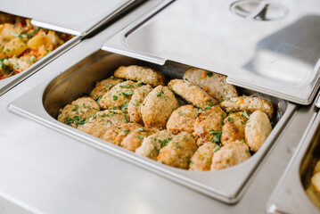 Different types of dishes in containers on the buffet table in the hotel restaurant