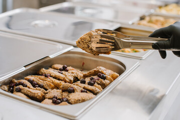 Different types of dishes in containers on the buffet table in the hotel restaurant