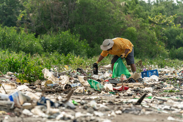 Man picks up plastic garbage on beach in the morning, Panama, Central America. © Amaiquez