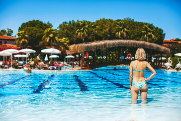 Naklejka premium Blonde woman standing in the swimming pool