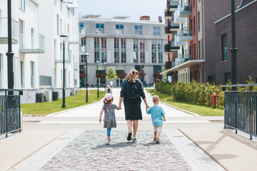 Mother and kids walking along the town