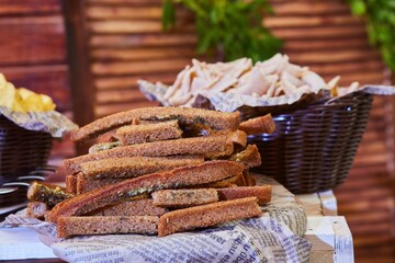 Loaves and crackers lie on newsprint. Light snack and table decoration.