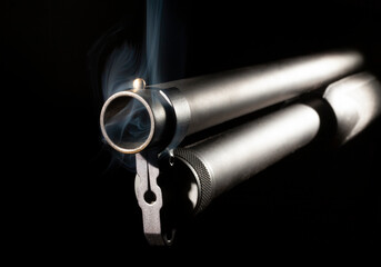 Smoking shotgun barrel on a dark background