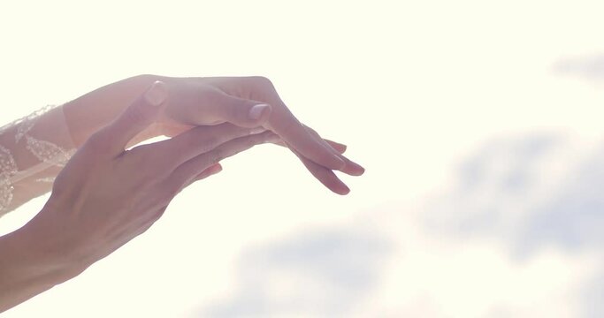 beautiful female hands with white sleeves clap their hands against the background of the sunny sky. Spanish flamenco dance element, hand clap. close-up