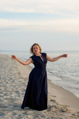 Beautiful woman dancing in dress near the sea at sunset - 498509107