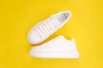 A pair of stylish women's leather shoes with laces (top view, side view) on a yellow background. Seasonal sales, promotions, discounts on casual shoes. Proper care for white skin.Copyspace