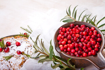 Delicious cranberry pie with fresh cranberries and herbs for Christmas on wooden plate