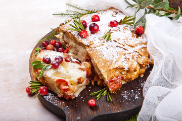 Delicious cranberry pie with fresh cranberries and herbs for Christmas on wooden plate