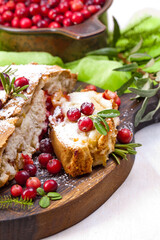 Delicious cranberry pie with fresh cranberries and herbs for Christmas on wooden plate
