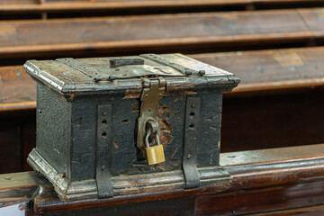 The church money box mounted on a pew in the church