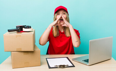 pretty blonde woman feeling happy,giving a big shout out with hands next to mouth. packer employee...