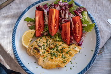 Top view of typical Italian dish of chicken breast with tomato