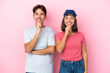 Young couple isolated on pink background smiling with a sweet expression