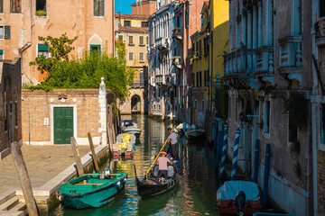 Fototapeta na wymiar VENICE, ITALY - August 27, 2021: Gondola sailing on a typical Venetian water street canals