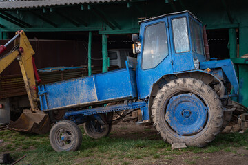 Small blue tractor are ready to hard work in small Ukrainian village