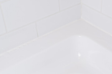 Waterproof joint filled with silicone sealant in the shower bath.