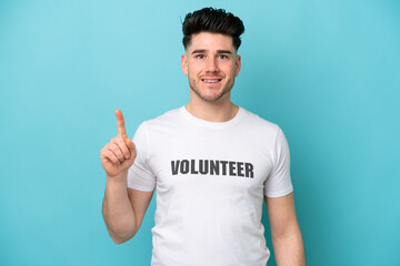 Young volunteer caucasian man isolated on blue background showing and lifting a finger in sign of the best