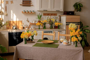 Happy easter! home interior kitchen with fresh flowers daffodils and Easter cakes