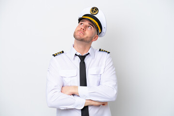 Airplane caucasian pilot isolated on white background looking up while smiling