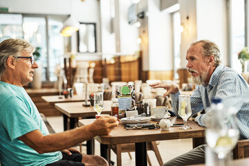 This place serves a great breakfast. Shot of two senior friends chatting at a table at their...