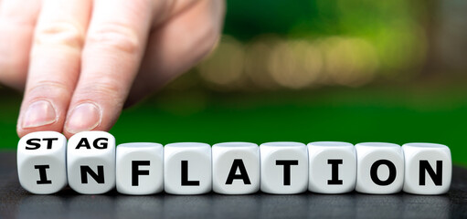 Hand turns dice and changes the word "inflation" to "stagflation".