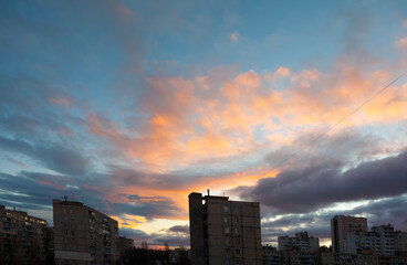 Fototapeta premium City, large apartment buildings against the background of the evening sky with clouds. Dramatic evening cloudscape in city