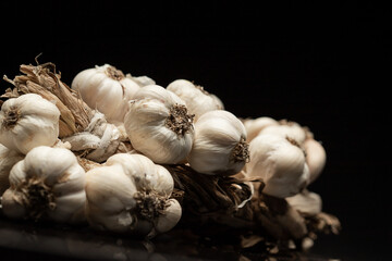 Fragrant Garlic wreath lies on dark background. Agriculture and farming