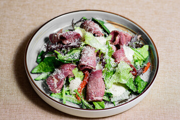 Salad of fresh vegetables from lettuce, meat, arugula, spinach, cucumber